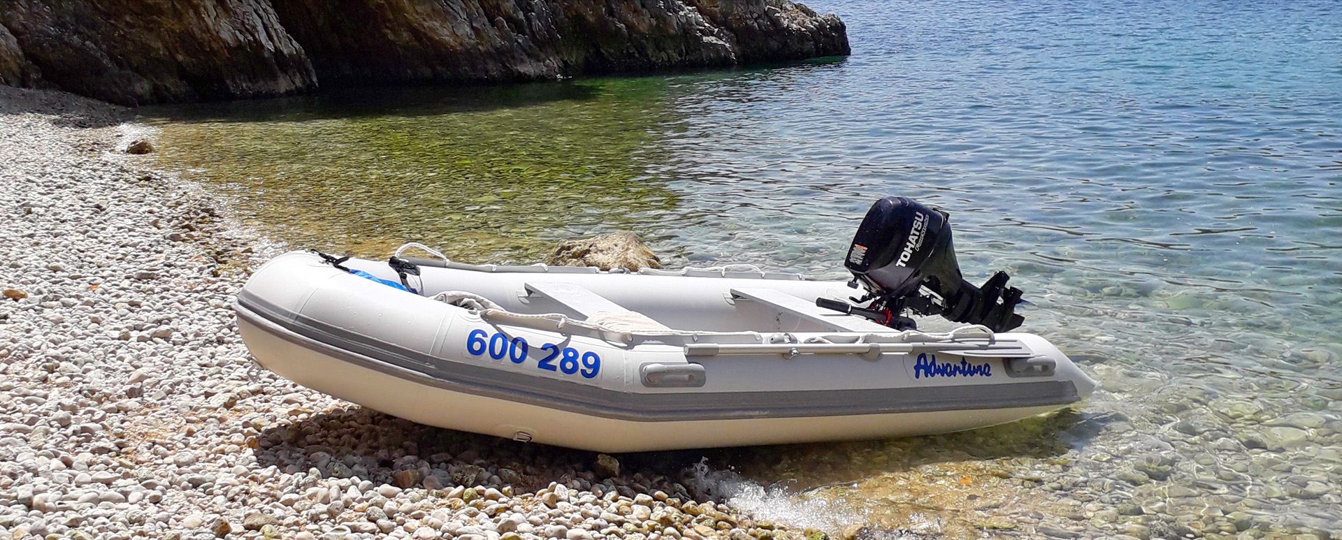 Nafukovací člun Adventure s motorem Tohatsu na břehu